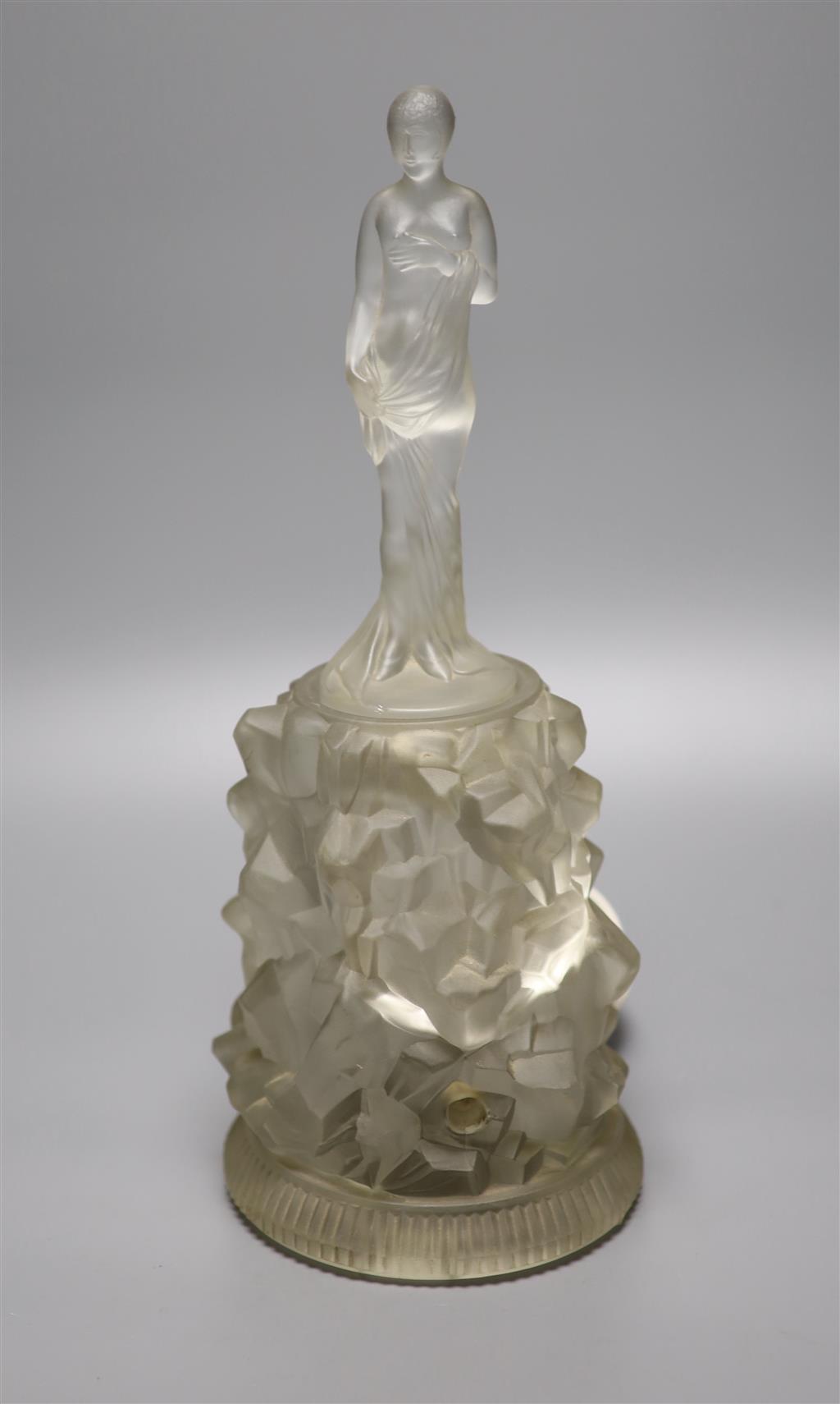 An Art Deco moulded glass figure on an illuminated glass stand